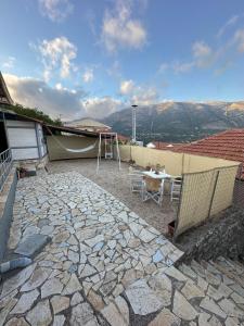 een patio met een tafel en een schommel bij Alice Apartment in Ayia Evfimia +34 foto's