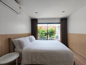 Postel nebo postele na pokoji v ubytování Merry house บ้านพักริมหาดบางแสน