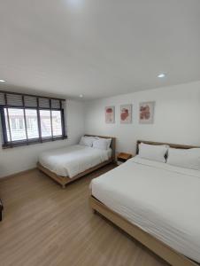 Postel nebo postele na pokoji v ubytování Merry house บ้านพักริมหาดบางแสน