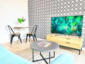 Una sala de estar con un televisor y dos sillas y una mesa. en Beautiful One Bedroom Apartment With View Of City, en San Diego