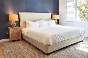ein Schlafzimmer mit einem großen weißen Bett mit zwei Lampen in der Unterkunft Dapper Retreat In Vibrant San Diego in San Diego