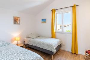 Appartement à 200 m de la plage في ميميزان: غرفة نوم بها سريرين ونافذة