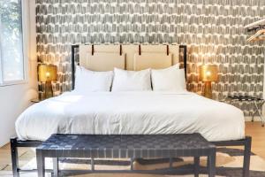 a bedroom with a large bed and a black bench at Cozy Couple's Corner In Downtown San Diego in San Diego