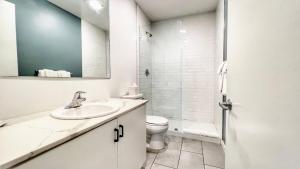 Un baño blanco con lavabo e inodoro. en Executive Escape In Downtown San Diego, en San Diego 12 fotos más
