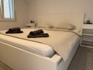 a large white bed with two brown towels on it at Villa EnVi in Novalja