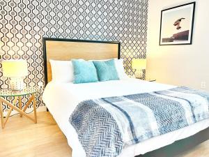 a bedroom with a large bed with blue pillows at The Leo - Unit 602 in San Diego