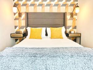 Un dormitorio con una cama grande con almohadas amarillas. en 3 Bedroom Penthouse In Downtown!, en San Diego