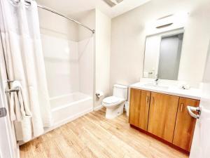 Un baño con inodoro, lavabo y ducha. en Sunset Stay In Downtown San Diego, en San Diego 13 fotos más