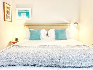 a bedroom with a bed with blue and white pillows at The Leo - One Bedroom Apartment W Private Balcony in San Diego