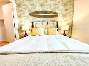 Un dormitorio con una gran cama blanca con dos lámparas. en San Diego Skyline - Downtown Apartment, en San Diego