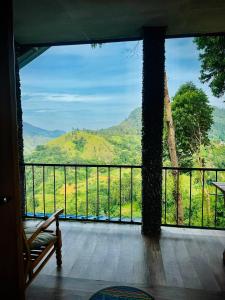 a room with a balcony with a view of the mountains at Will Guest Homestay in Ella
