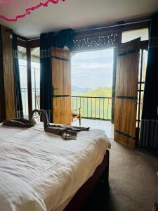 a bedroom with a large bed with a large window at Will Guest Homestay in Ella