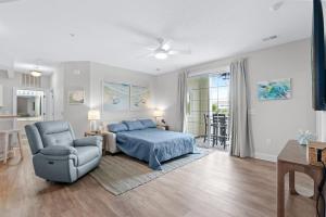a bedroom with a bed and a couch and a chair at The Havens Barefoot Resort Unit 727 in North Myrtle Beach +28 photos