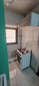 Una pequeña cocina con estufa y ventana. en AP CENTRAL, en Campina Grande 5 fotos más