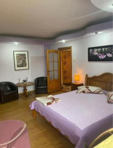 a bedroom with a bed and a table and chairs at Central Home in Piatra Neamţ