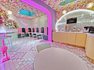 a restaurant with pink and purple floors and tables and chairs at Hotel La Petite Rosa in Paris