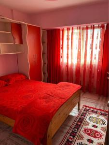 a bedroom with a bed with a red comforter and a window at Central Home in Piatra Neamţ +16 photos