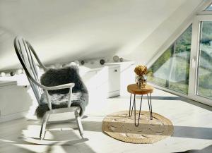 a white room with a chair and a table at Relax house Aurora in Jasenovica