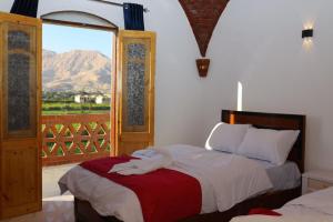 a bedroom with a bed with a view of a mountain at Quiet Gate Guest House in Al Aqālitah +112 photos