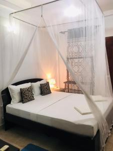 una camera da letto con un letto con zanzariera di Kavee Transit Hotel a Katunayake