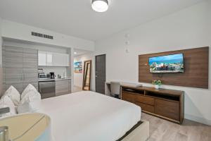 una camera da letto con un letto, una scrivania e una televisione di CH Luxury Condos & Studios On The Beach a Hollywood