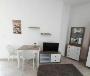 a room with a table with chairs and a television at Hotel Room in Aqua Palms Hurghada in Hurghada