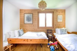 two beds in a room with wooden walls at Duplex w Sauna Within the Residence in Champéry