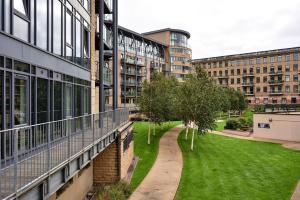 an external view of a building with a lawn and trees at Northern Lights Apartment in Saltaire
