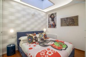 Un dormitorio con una cama con una pintura. en Amare Penthouse with Hot Tub Facing the Sea, en Alghero