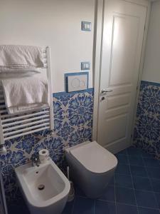 a blue and white bathroom with a toilet and a sink at La Casa di Pitti in Anacapri