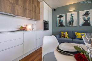 Una cocina y una sala de estar con una mesa y un sofá. en Amare Penthouse with Hot Tub Facing the Sea, en Alghero