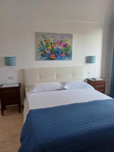 a bedroom with a bed and a painting on the wall at La Casa di Pitti in Anacapri
