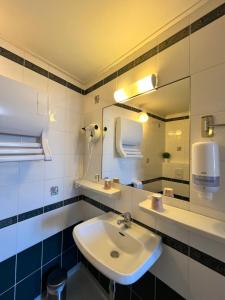 a bathroom with a sink and a mirror at Hotel du Nord - Ville-Haute in Saint-Flour