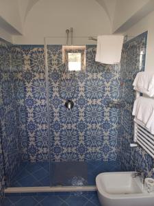 a blue tiled bathroom with a shower and a sink at La Casa di Pitti in Anacapri