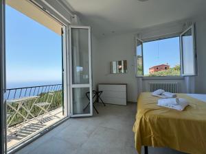 a bedroom with a bed and a balcony with the ocean at Ca' dii Bürsa - HOMY 5 TERRE in Volastra