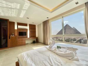 una camera con letto e vista sulle piramidi di Gaia Pyramids View INN a Il Cairo