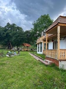 a small house in a field next to a yard at Căsuța Bunicilor din Rai in Tulgheş