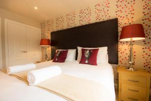 a bedroom with a large white bed with red pillows at Farley in Matlock