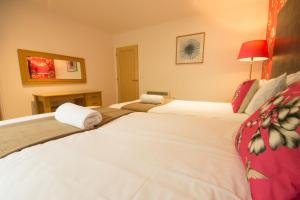two beds in a hotel room with two white beds at Farley in Matlock +1 photo