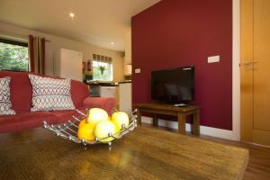 a living room with a red couch and a bowl of fruit at Farley in Matlock