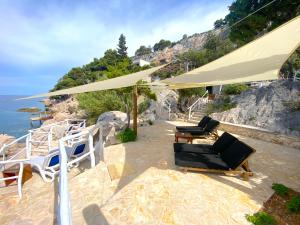 a group of chairs and umbrellas on a beach at Apartments Villa Marcelina in Hvar