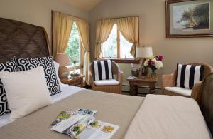 a hotel room with a bed and two chairs at Abbey's Lantern Hill Inn in Ledyard Center