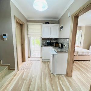 een keuken met witte kasten en een kamer met een bed bij Altelal Travel in Trabzon