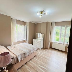 een slaapkamer met een bed, een dressoir en 2 ramen bij Altelal Travel in Trabzon +24 foto's