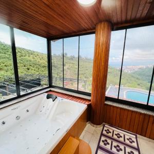een groot bad in een kamer met ramen bij Altelal Travel in Trabzon