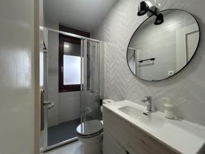 a white bathroom with a sink and a mirror at Loft in Uribarri in Bilbao