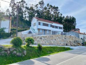 a house on a hill with a stone wall at Casa das Laixas in Laxe +60 photos