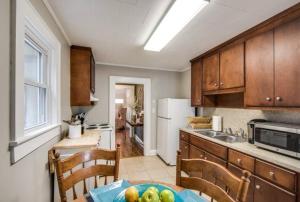 a kitchen with a table with a bowl of fruit on it at Southern Charm Cottage in Hickory +12 photos
