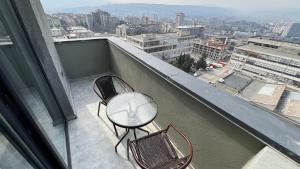 a balcony with two chairs and a table on a building at Lux Aparments Guramishvili in Tbilisi City