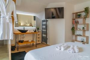 een slaapkamer met een bed, een wastafel en een spiegel bij Amboise et Volupté centre-ville in Amboise